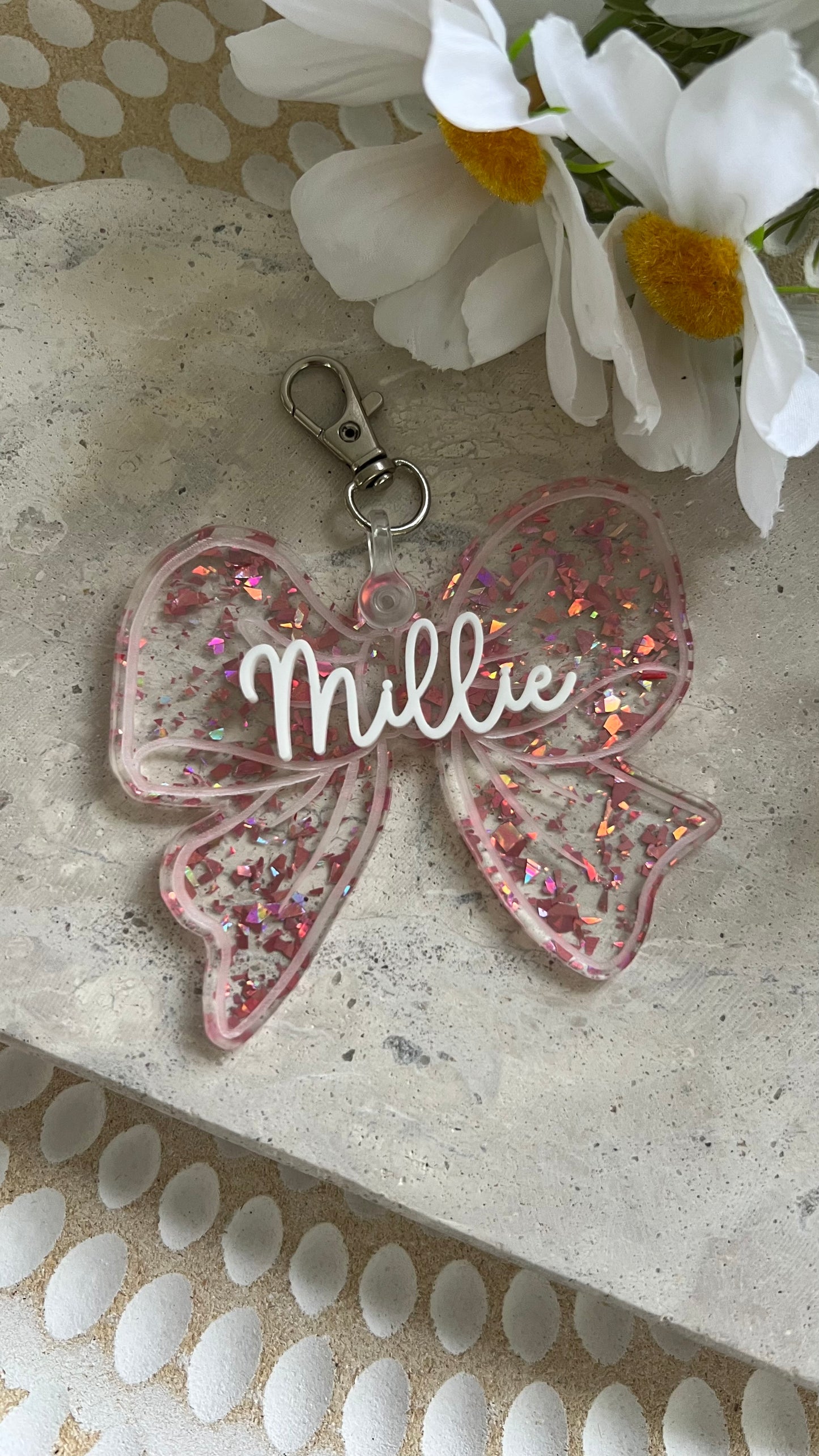 Pink glittery bow keychain made with acrylic personalised with name