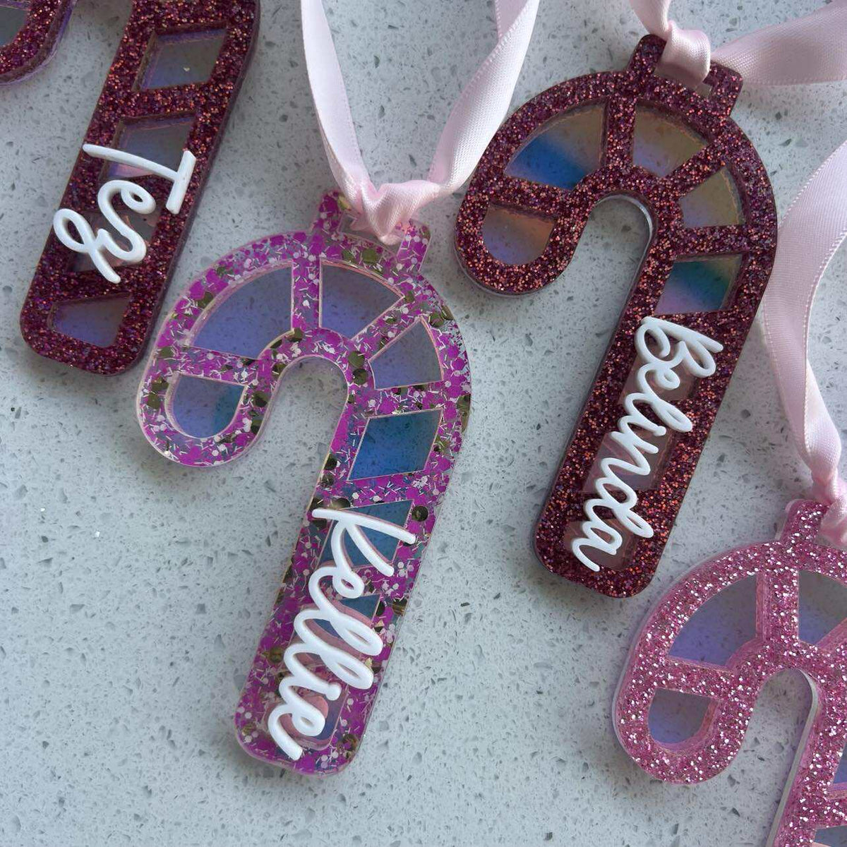 Decorative candy cane ornaments with glittery finish and light background with name added