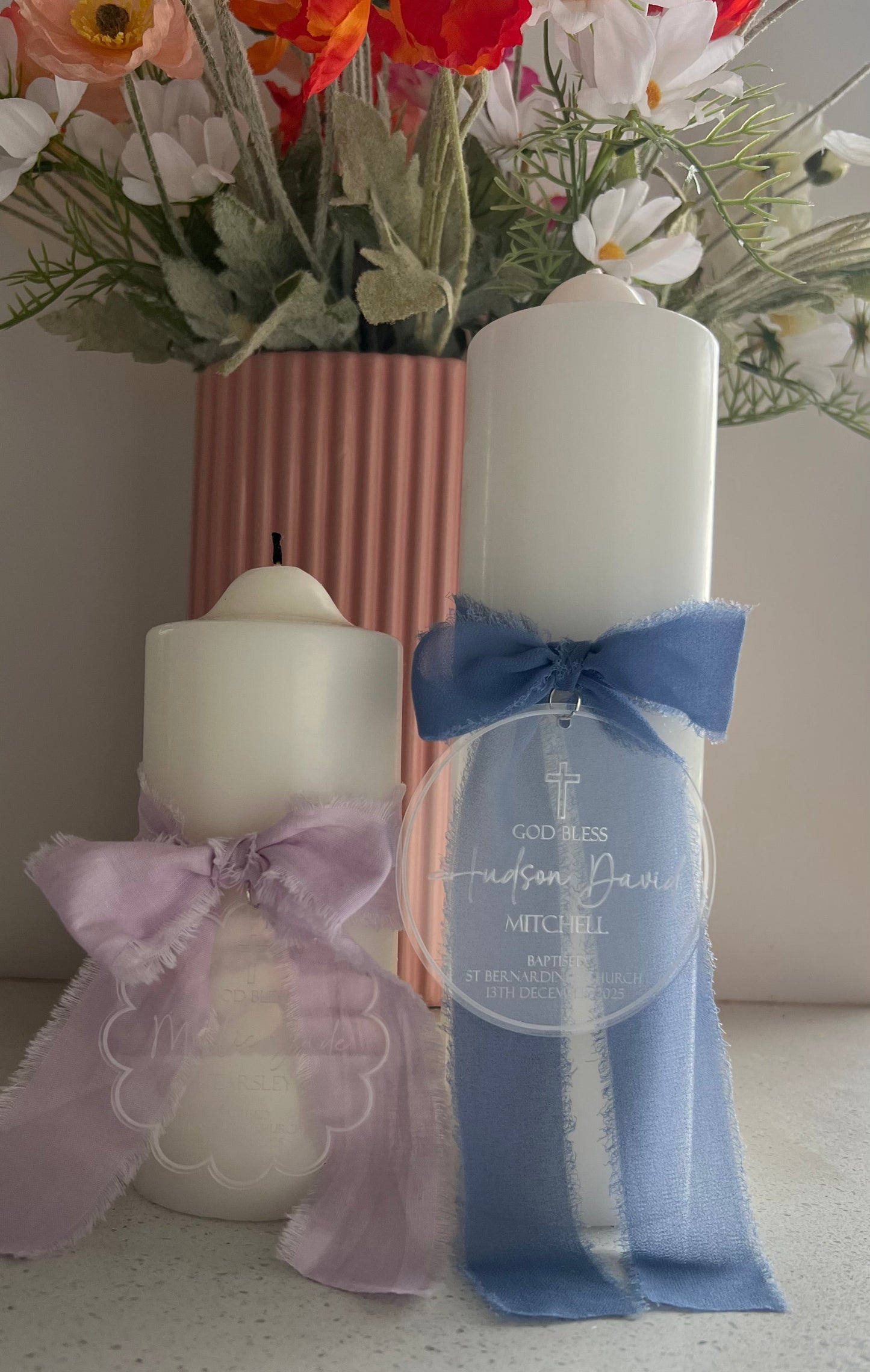 two different sized Christening Candle with a blue and purple bow and personalised frosted and clear tag with details