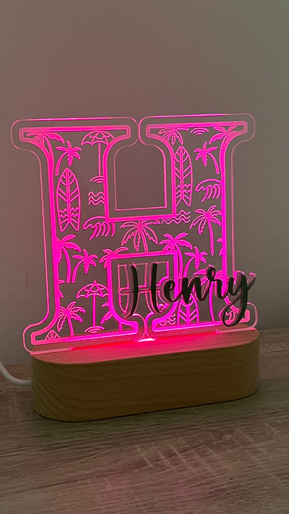 Decorative lamp with a letter with Palm trees and surf boards engraved in the background and an acrylic name on the front in a LED light base