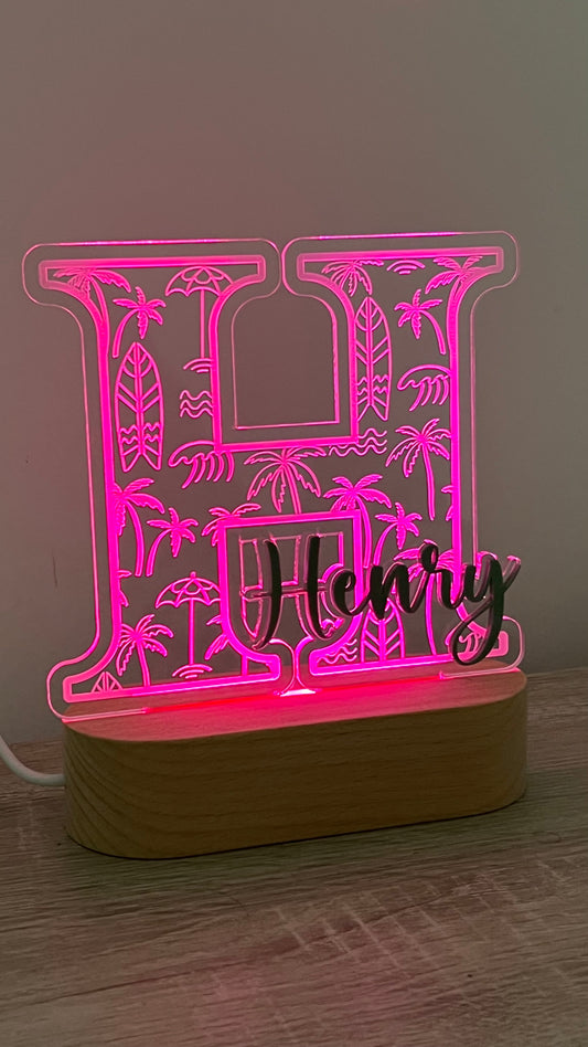 Decorative lamp with a letter with Palm trees and surf boards engraved in the background and an acrylic name on the front in a LED light base