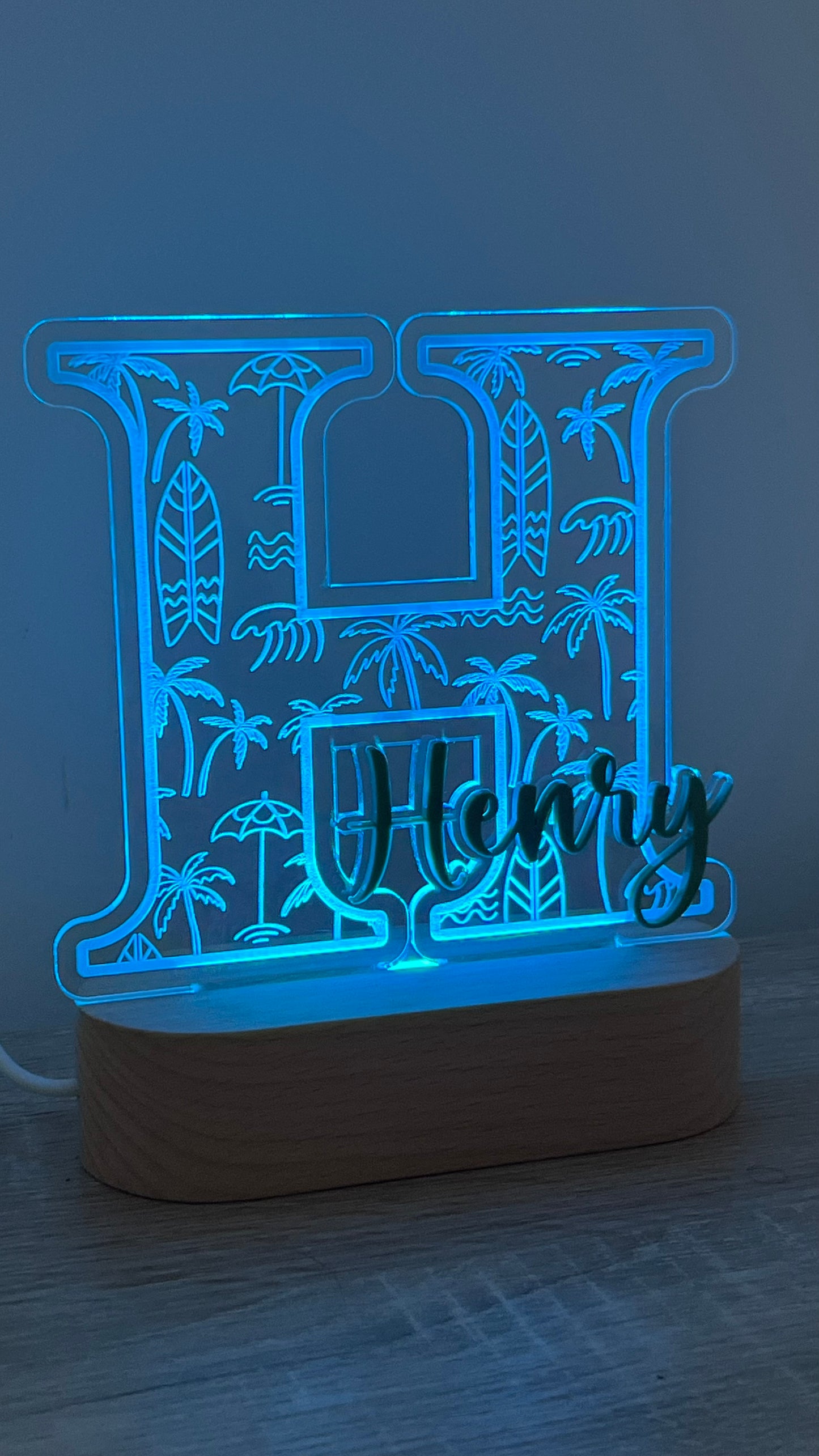 Decorative lamp with a letter with Palm trees and surf boards engraved in the background and an acrylic name on the front in a LED light base