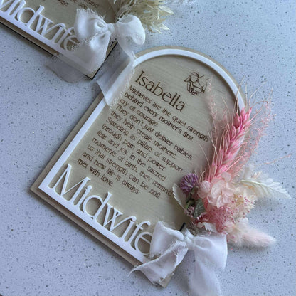 Decorative sign with floral elements and text on a textured surface to thank midwives 