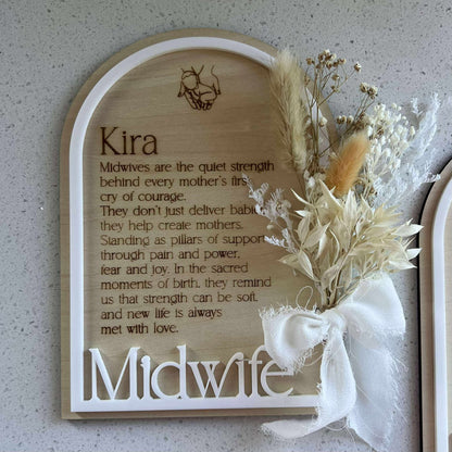 Decorative sign with floral elements and text on a textured surface to thank midwives 
