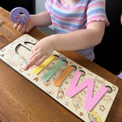 Child playing with colorful wooden letters on a wooden board