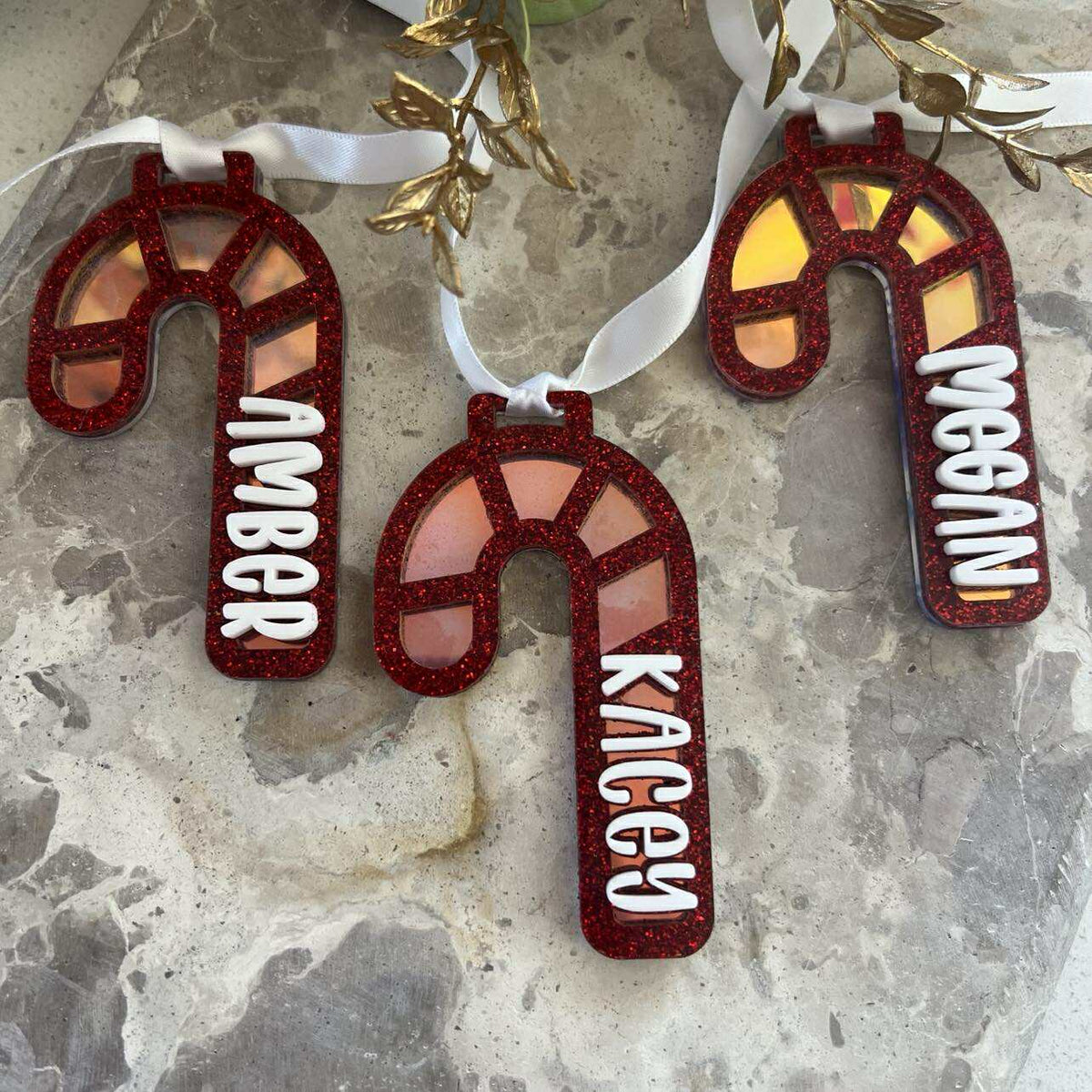Decorative candy cane ornaments with red glittery finish and light shimmery background with name added