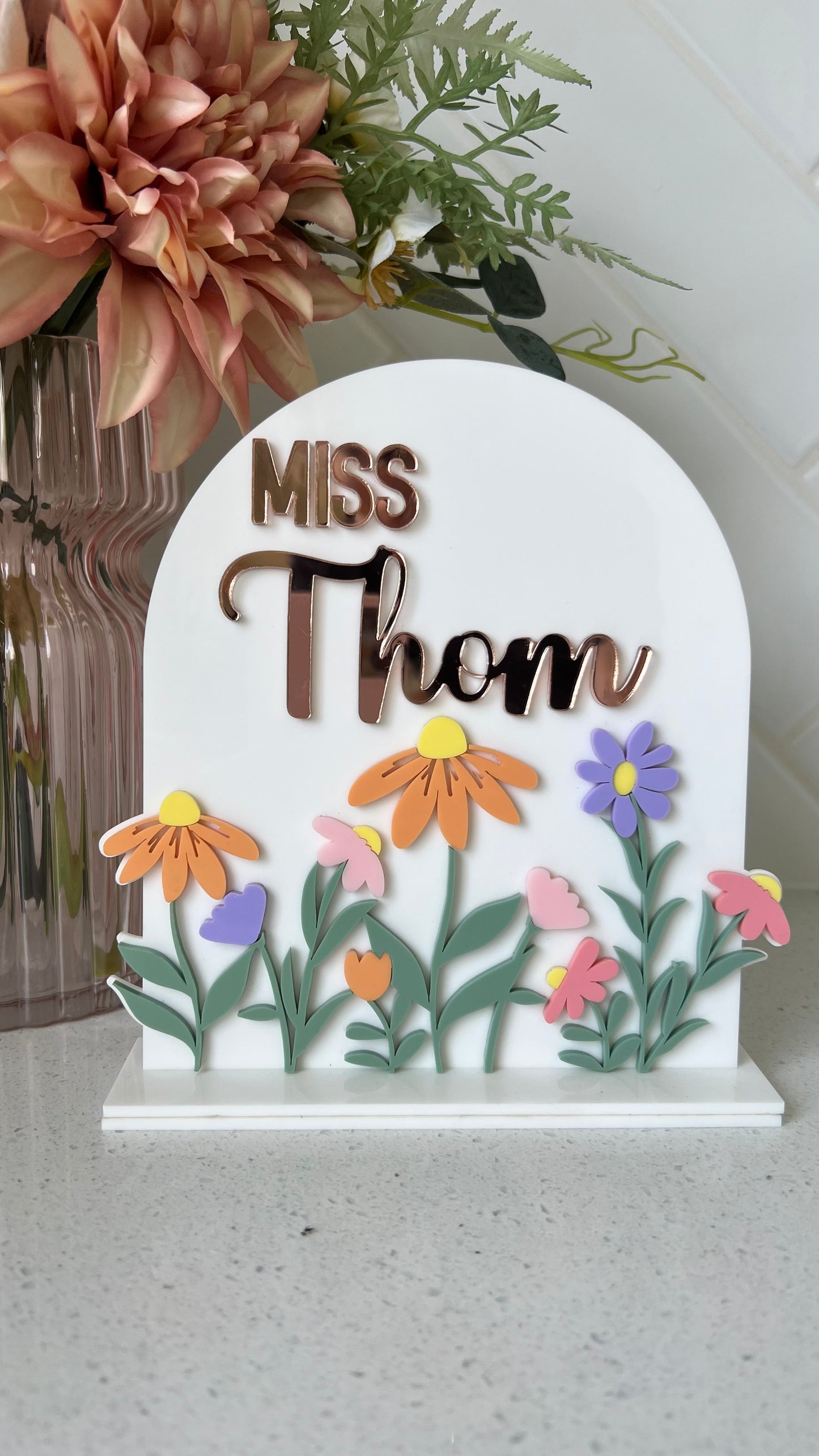A personalised acrylic desk sign with a floral design and customisable text that reads teachers name 
