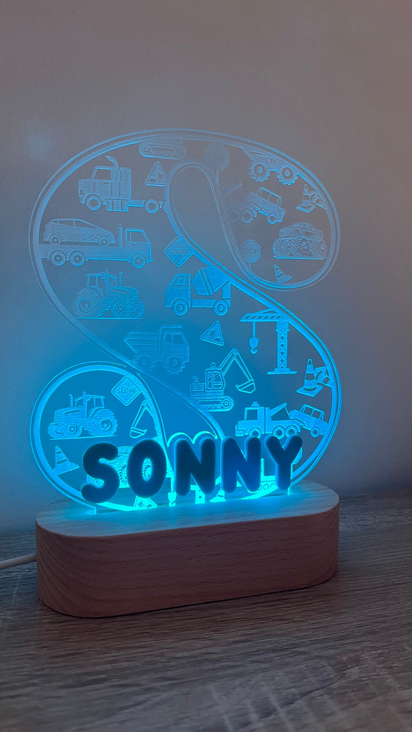 Decorative lamp with letter and name on it with engraved trucks on background